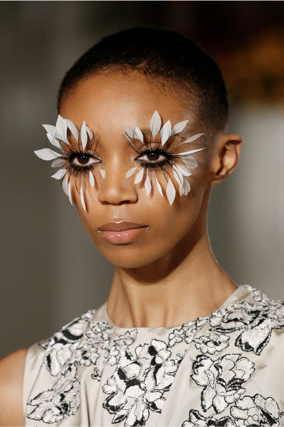 Runway model with gold glitter eyeshadow and gold crochet flowers in her hair