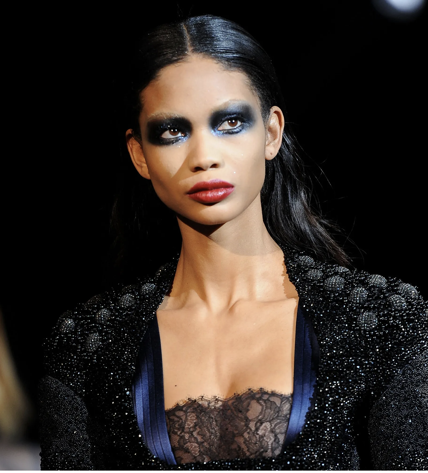Runway model with smudged navy smoky eyes and a deep red lip