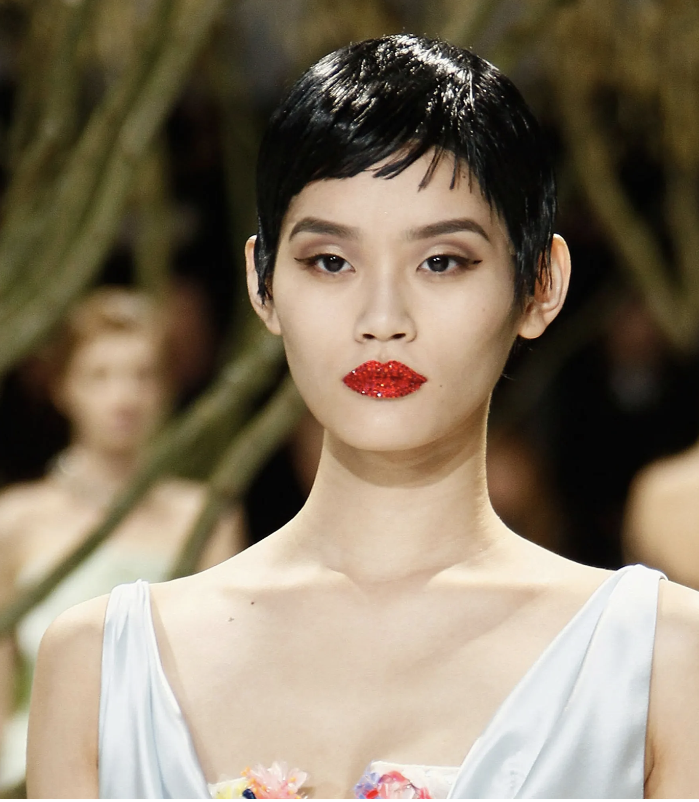 Runway model with a pixie cut and crystal-encrusted red lips